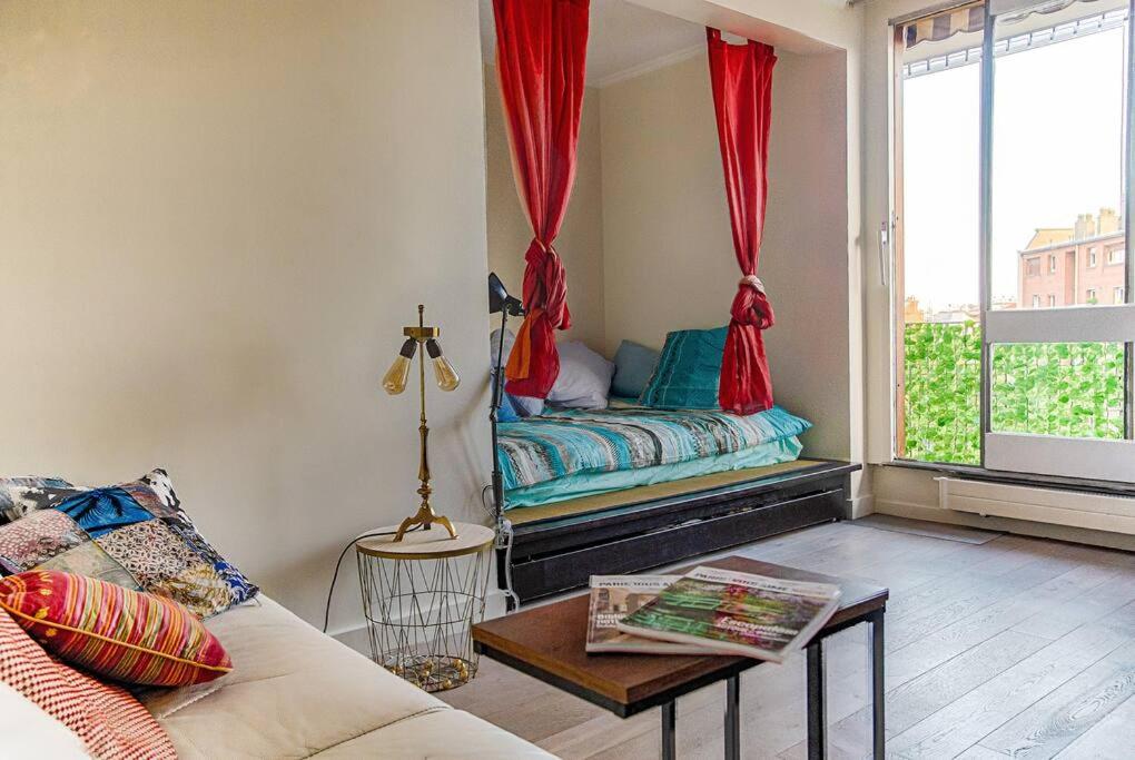 un salon avec un canapé et une fenêtre dans l'établissement Studio with Balcony, à Paris