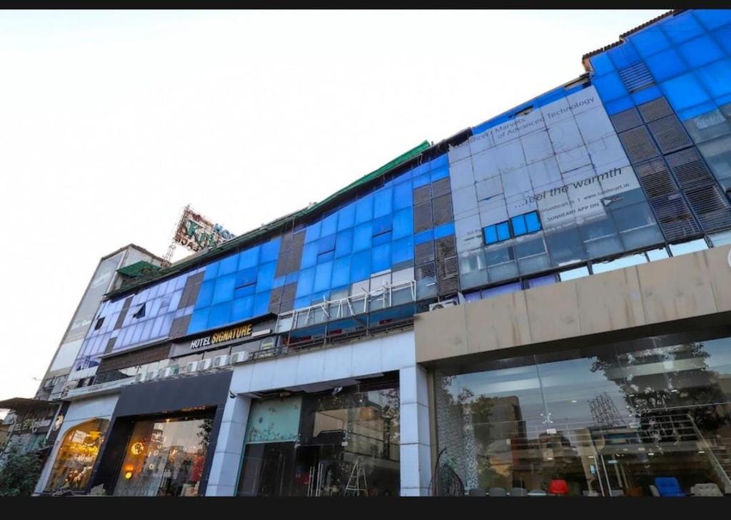 un gran edificio de cristal con reflejos en las ventanas en hotel shreenivas en Ahmedabad