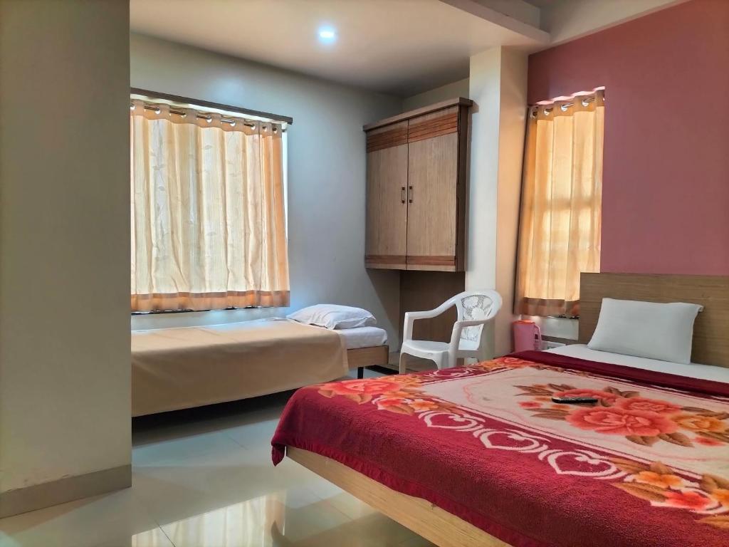 Postel nebo postele na pokoji v ubytování HOTEL SAI SURYA