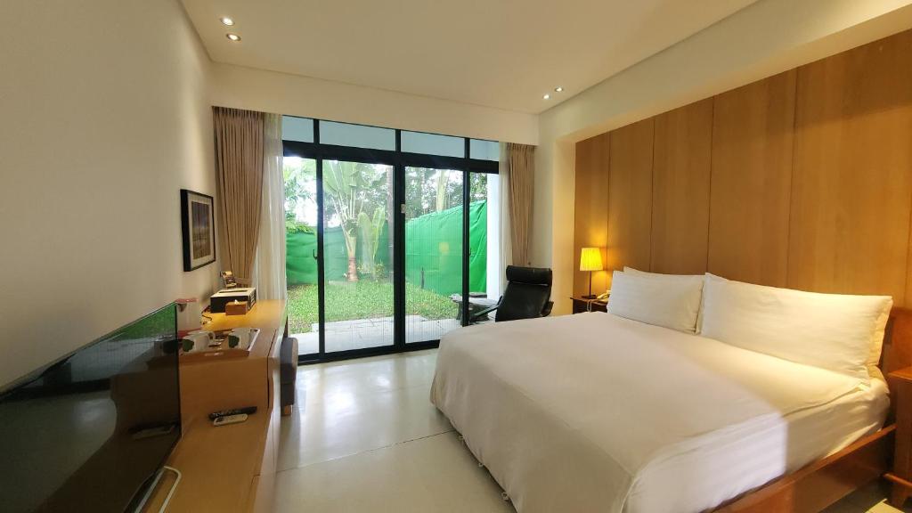 a bedroom with a white bed and a large window at Fu Wan Cafe Villa in Donggang