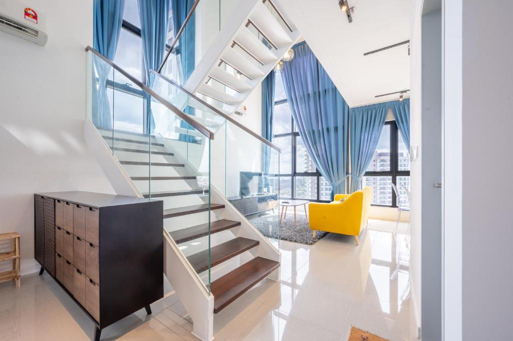a staircase in a living room with a yellow chair at HighPark Suites by Airhost in Petaling Jaya