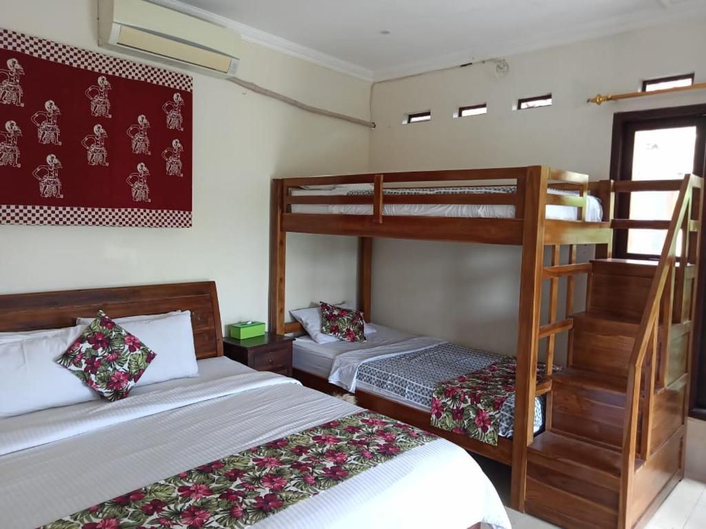 a bedroom with two bunk beds and a staircase at Rosella Cottage - Homestay - Kitchen Yogyakarta in Yogyakarta