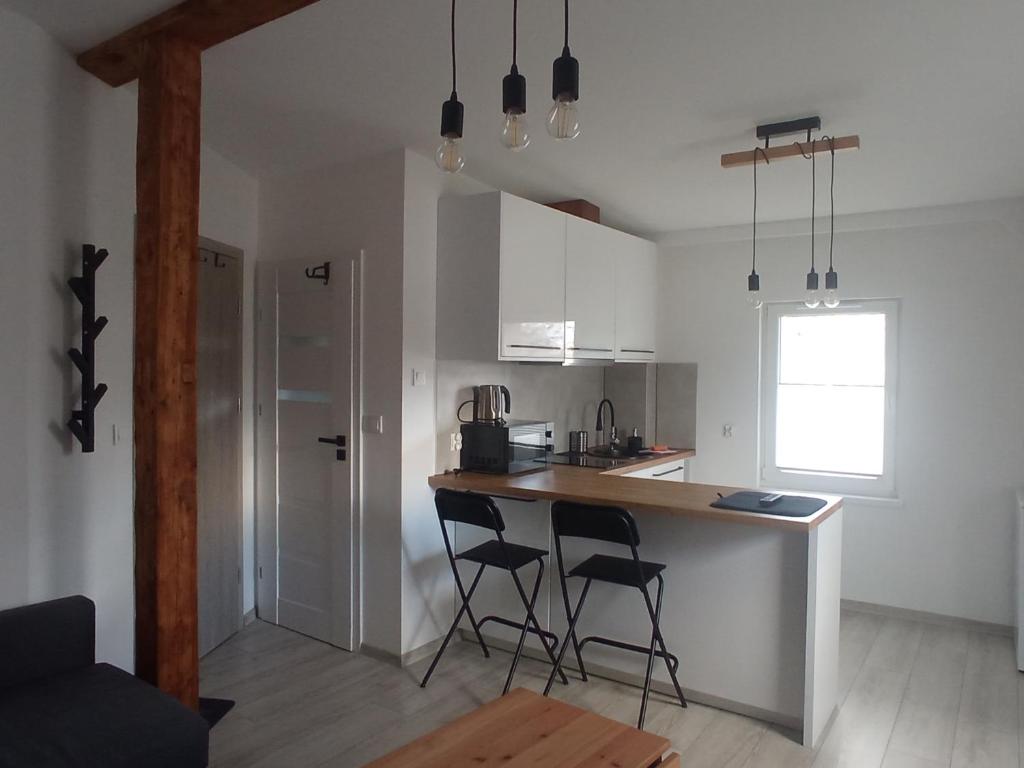 eine Küche mit zwei Barhockern und einer Arbeitsplatte in der Unterkunft Apartament Wolności in Jelenia Góra