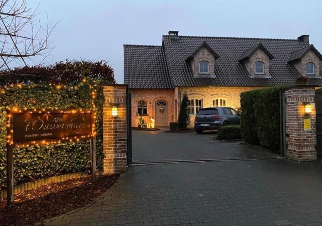 Vakantiewoning - ‘t Ouwershuys في Opoeteren: منزل به علامة أمام ممر