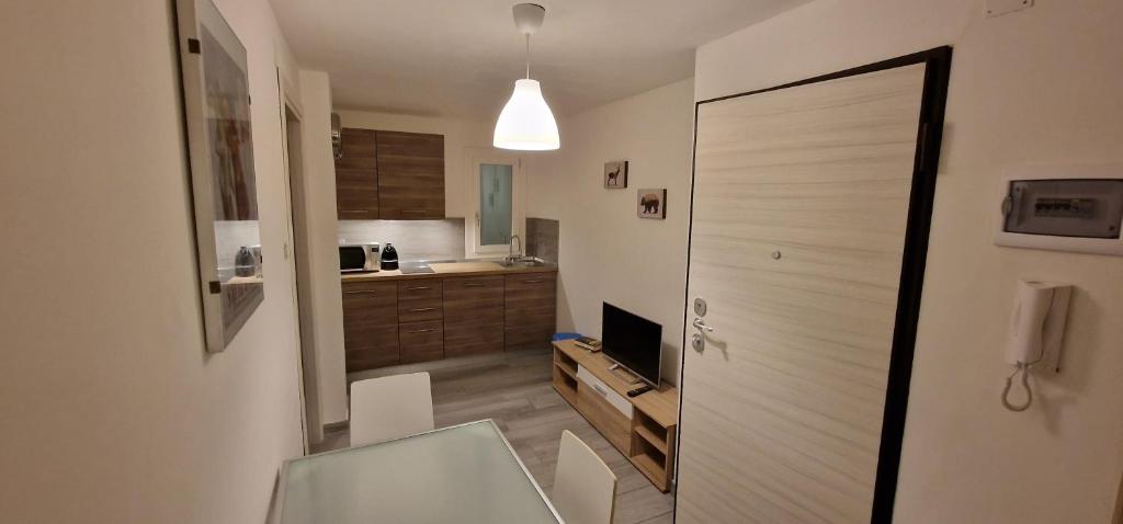 una camera con cucina con porta e televisore di Sweet House a Sauze d'Oulx