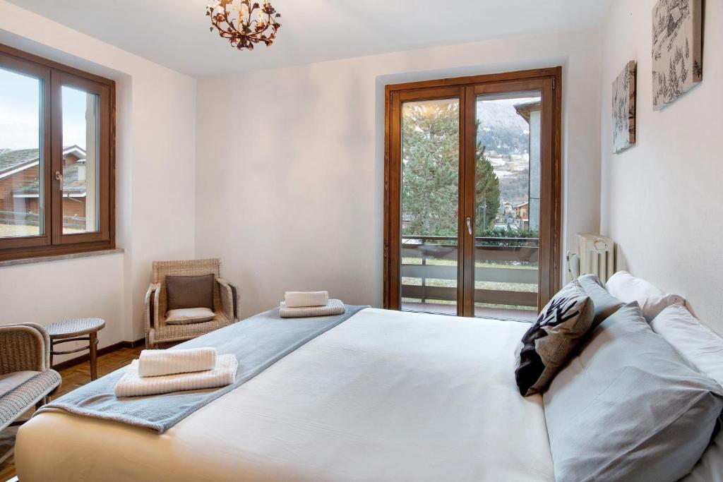 a bedroom with a large bed and a window at Casa Rossella in Bormio