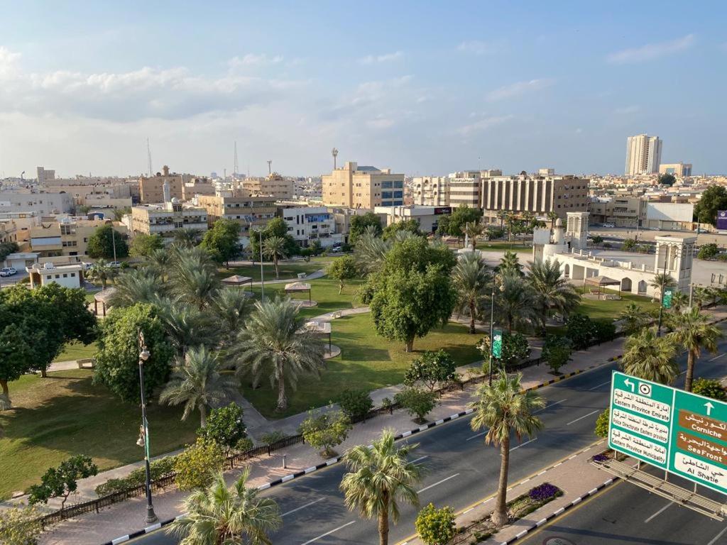 a view of a city with palm trees and a street at Rest Park Hotel in Dammam
