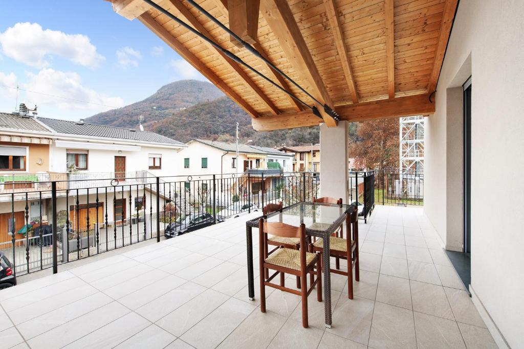 een patio met een tafel en stoelen op een balkon bij Casa Tovini in Pisogne