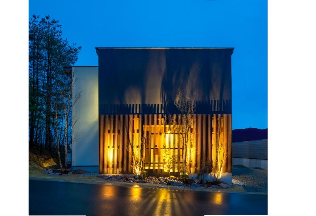 ein großes Glasgebäude mit Lichtern in der Nacht in der Unterkunft villa-rizo 山田 in Takayama