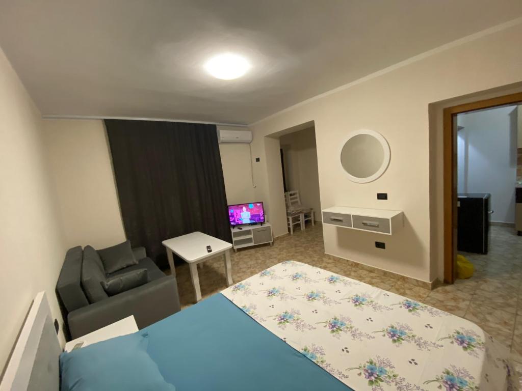 a living room with a bed and a couch at Cappuccino City Center Apartment in Lezhë