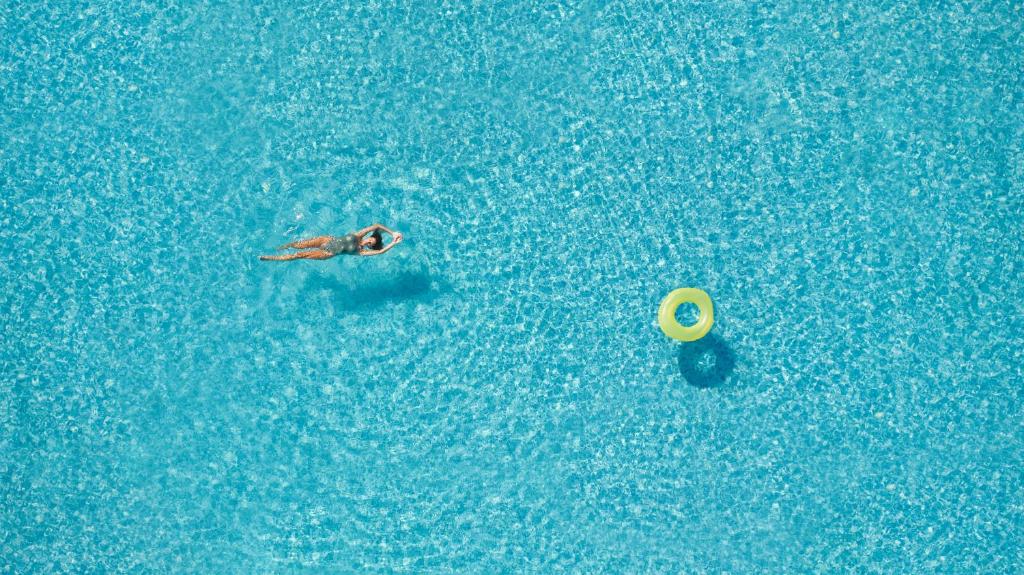 eine Person, die mit einem Frisbee im Wasser schwimmt in der Unterkunft Little Bird Lesvos in Petra