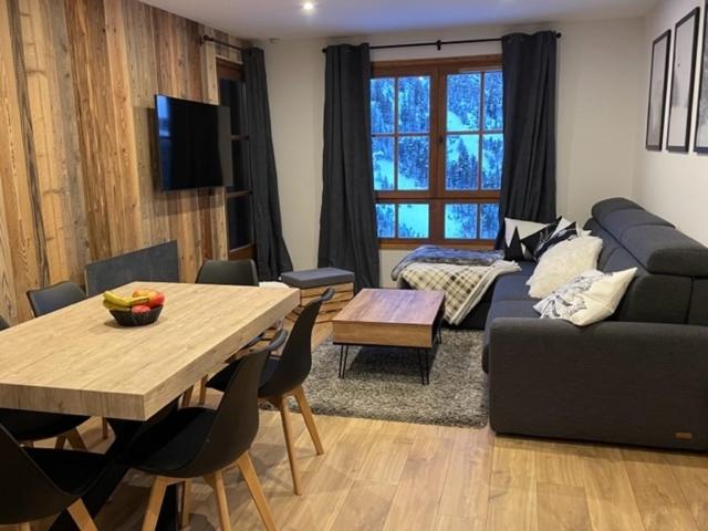 a living room with a couch and a table at Arcs 1950 Appartement prestige Ski InOut 6 pax in Bourg-Saint-Maurice