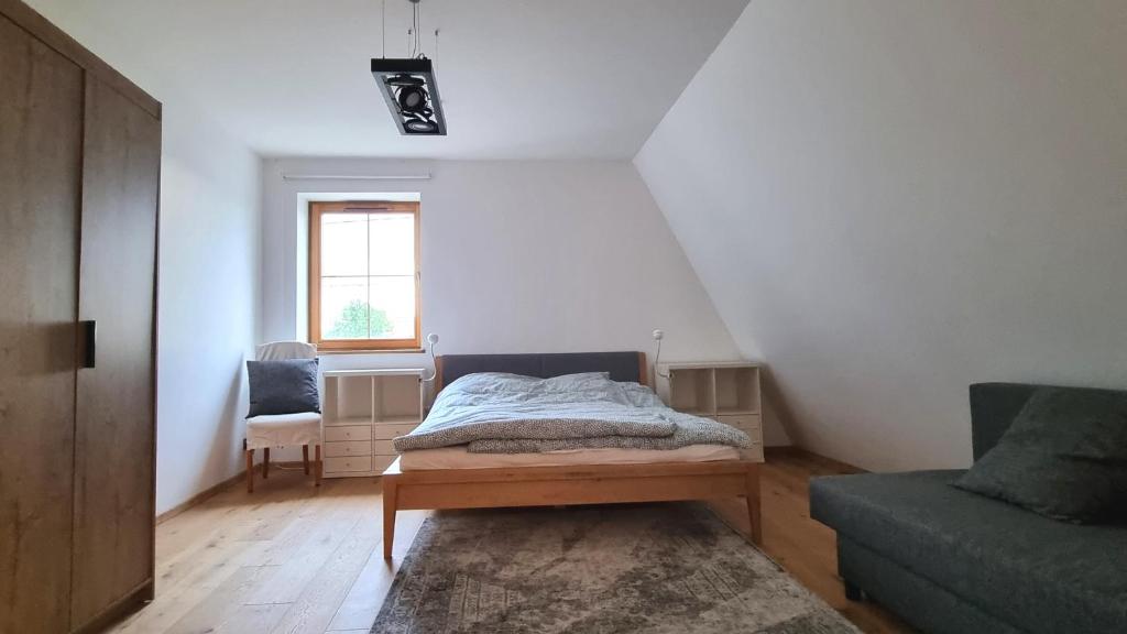 sypialnia z łóżkiem, krzesłem i oknem w obiekcie Villa SEEhochDREI - Ferienhaus w mieście Dobiesławiec
