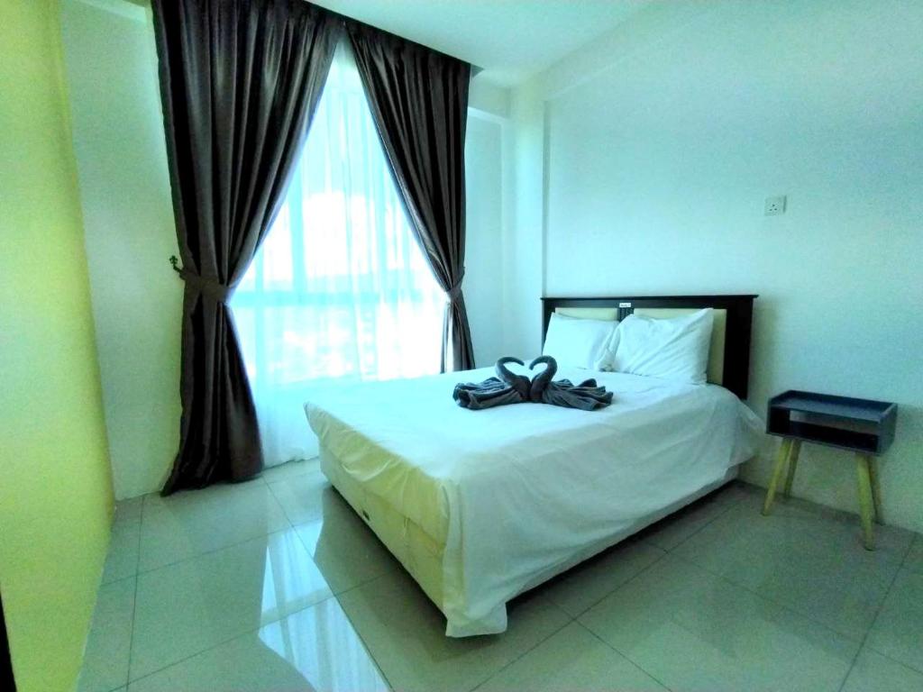 a bedroom with a large white bed with a window at 191 Cozy Casa Kayangan 3BR 6pax by Grab A Stay in Ipoh