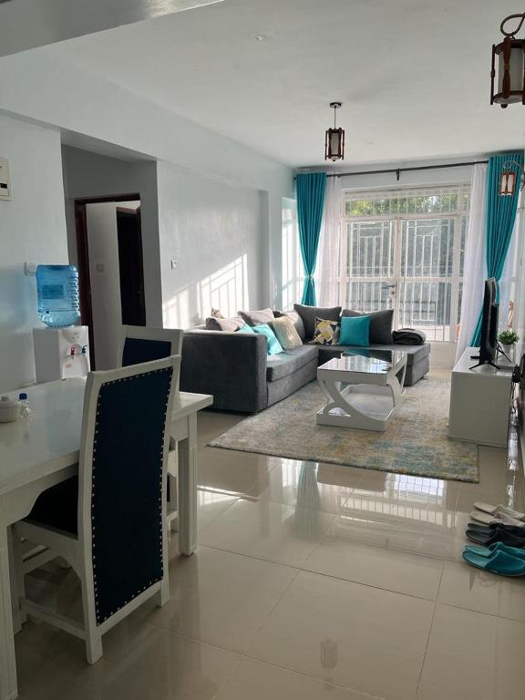 KerichoにあるZoe Homes Greypoint 1 and 2bedroom Apartment 301のソファとテーブルのあるリビングルーム