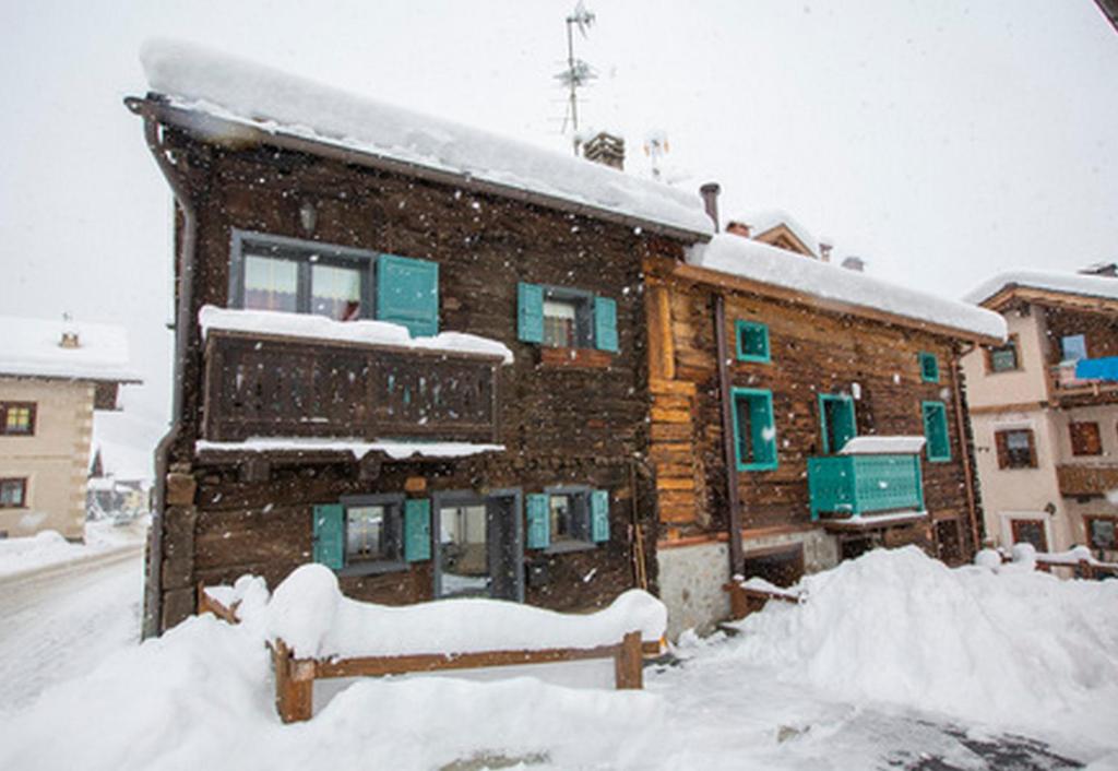 un bâtiment recouvert de neige devant dans l'établissement Marlies Ski in - Ski out Mt 50 - Happy Rentals, à Livigno