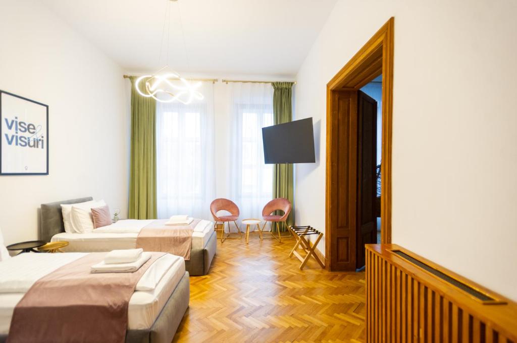 a hotel room with two beds and a couch at Althof Apartments in Sibiu