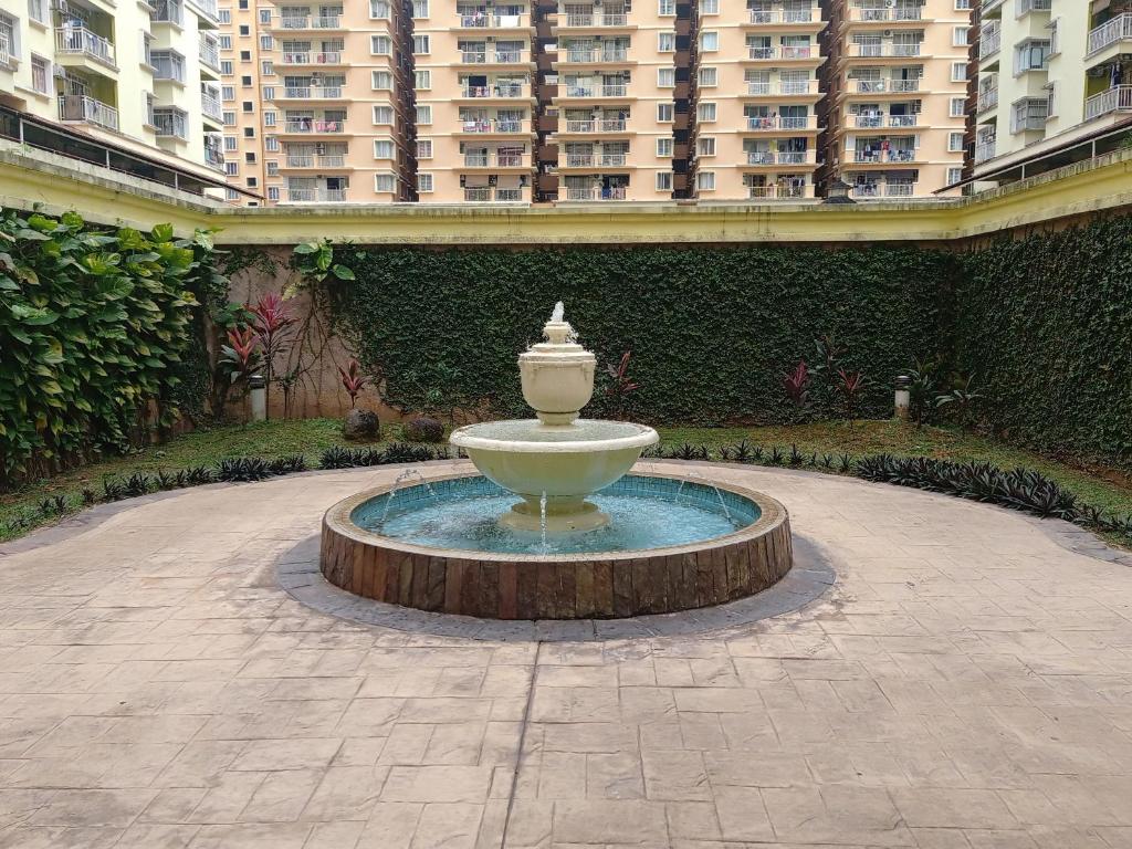 a fountain in the middle of a courtyard with tall buildings at 3 rooms PV3 at DANAU KOTA SETAPAK in Kuala Lumpur