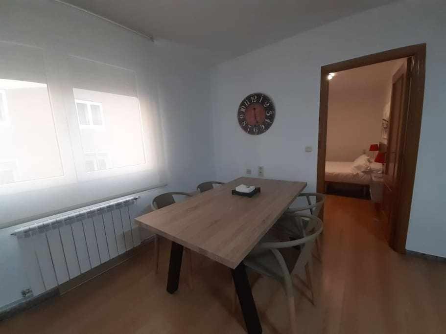 een houten tafel en stoelen in een kamer met een spiegel bij Apartamento Abadía in Teruel