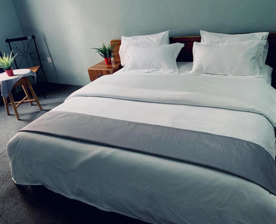 a large bed with white sheets and pillows at Kigali viewStay in Kigali