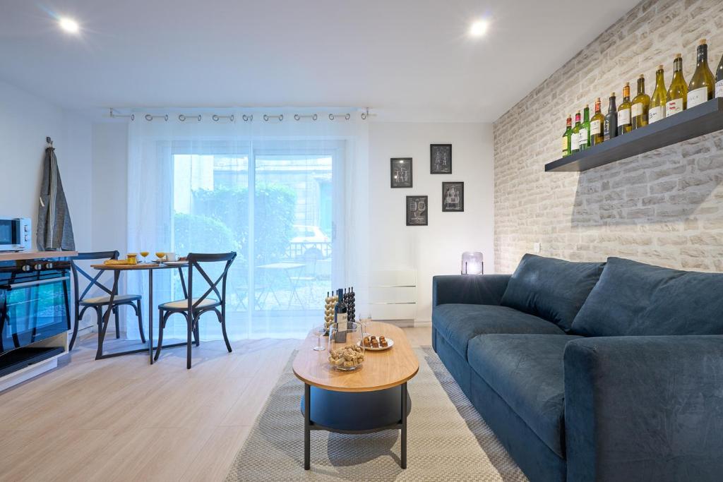 a living room with a blue couch and a table at THEM'APPART CHARTRONS in Bordeaux