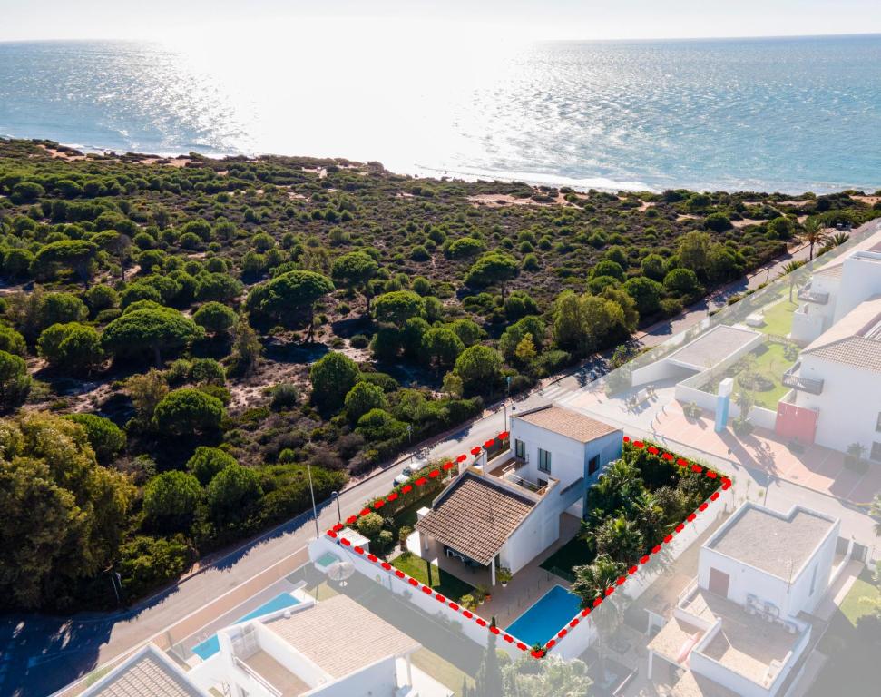 科尼爾－德拉弗龍特拉的住宿－Villa Los Pinares de Monaco en Roche, Conil, Cádiz，背景中海洋的房屋的空中景观