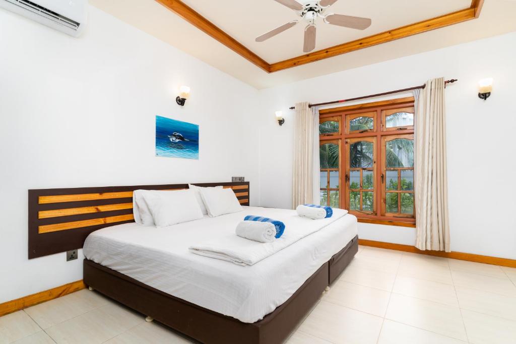 a bedroom with a large bed and a window at Ukulhas View in Ukulhas