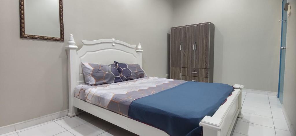 Schlafzimmer mit einem Bett und einem Holzschrank in der Unterkunft Al Irfan Homestay Tmn SgDua Utama in Butterworth