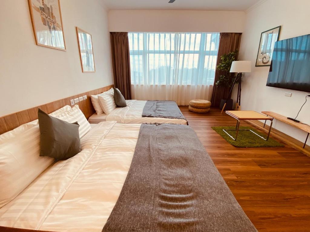a living room with two beds and a flat screen tv at Kenting Little House in Kenting
