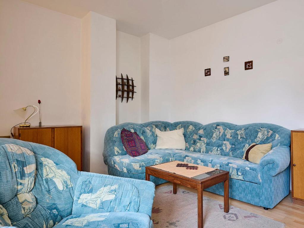salon z 2 niebieskimi kanapami i stołem w obiekcie Apartment Klondajk by Interhome w mieście Harrachov