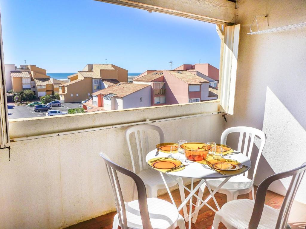 un balcon avec une table, des chaises et une fenêtre dans l'établissement Apartment Les Balcons de la Méditerranée-2 by Interhome, à Narbonne-Plage