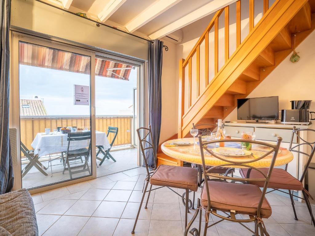 ein Wohnzimmer mit einem Tisch und Stühlen sowie einem Balkon in der Unterkunft Apartment Le Capitole-8 by Interhome in Fréjus