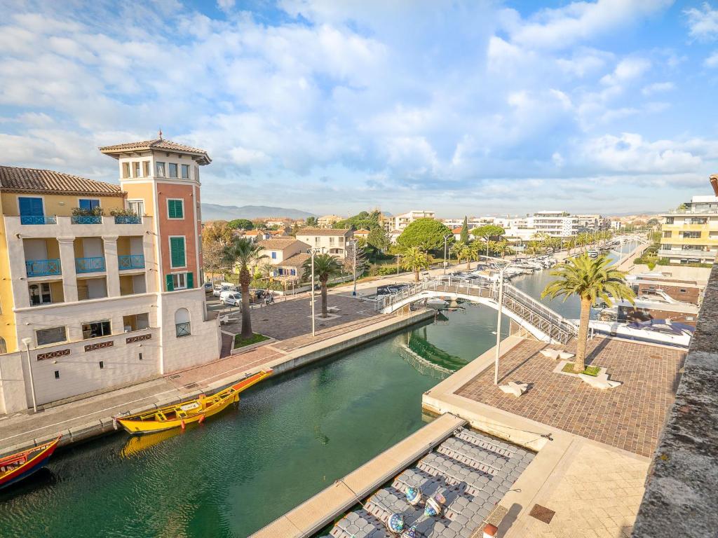 une rivière avec un bateau jaune dans une ville dans l'établissement Apartment Port Quiétude-1 by Interhome, à Fréjus