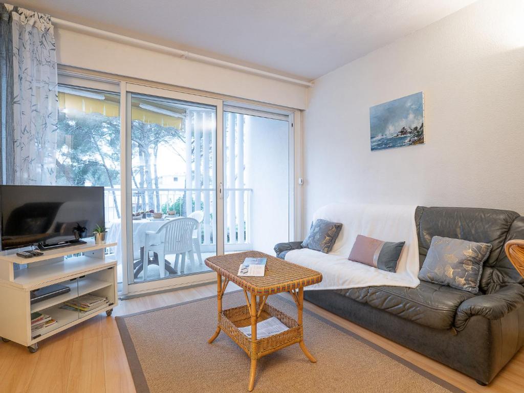 a living room with a couch and a tv and a table at Studio Résidence Le Boréal-1 by Interhome in Saint-Raphaël