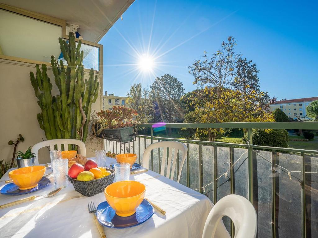 une table avec des bols de fruits sur un balcon dans l'établissement Apartment Le Grand Parc by Interhome, à Fréjus