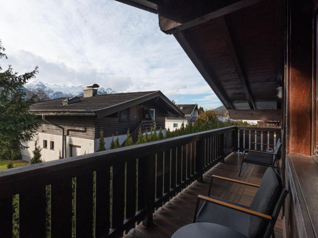 a balcony with chairs and a view of a house at Apartment Alpenchalets - ZSE202 by Interhome in Zell am See
