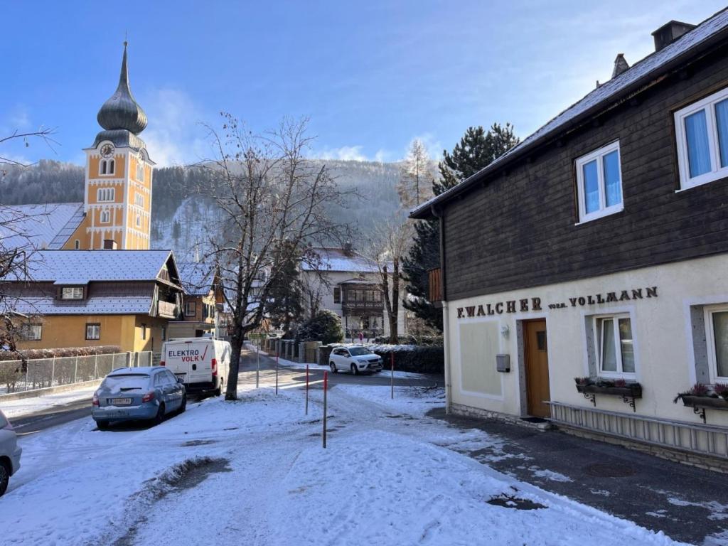 une rue enneigée dans une ville avec un bâtiment dans l'établissement Apartment Dachsteingasse by Interhome, à Schladming
