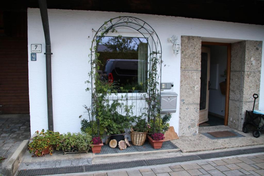 uma arcada numa casa com vasos de plantas em Ferienwohnung Pickl - Anna-Maria Pickl em Anger