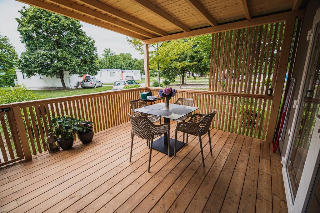 un patio con mesa y sillas en una terraza en Premium Mobile Homes with thermal riviera tickets, en Čatež ob Savi