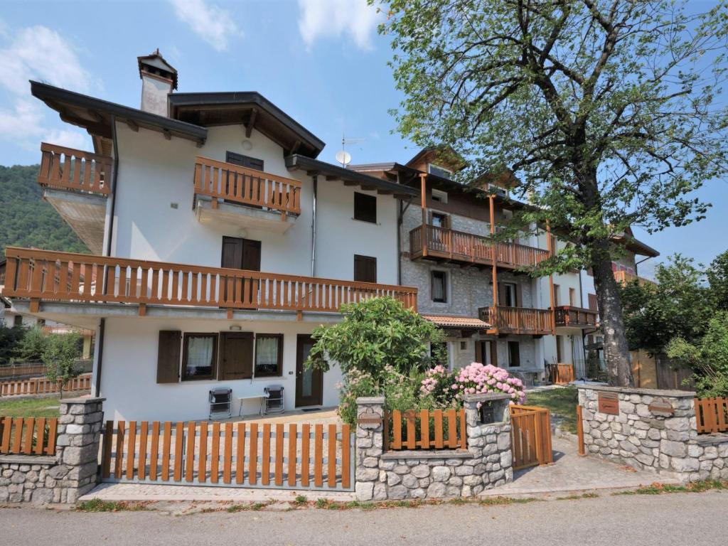 a large white house with wooden balconies and a fence at Apartment Albergo Diffuso - Cjasa de Pagnocca-1 by Interhome in Barcis