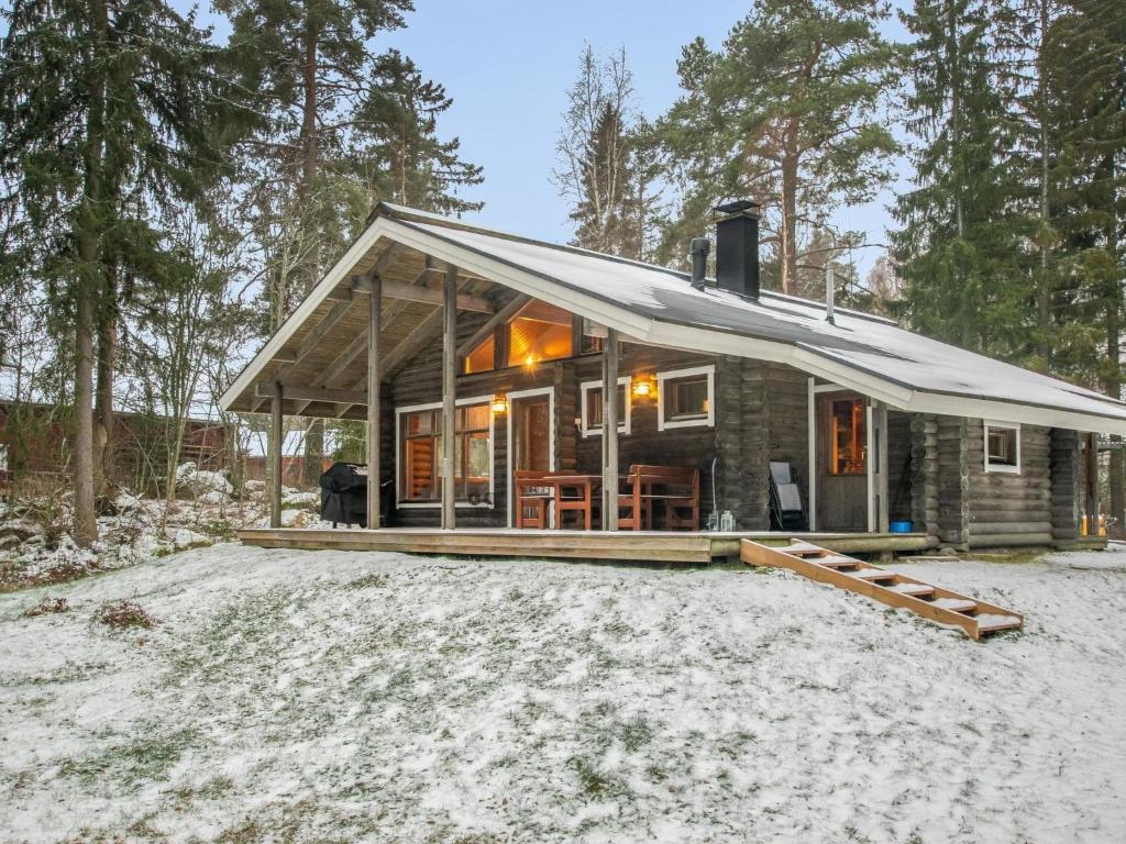 a log cabin with a roof on a snow covered field at Holiday Home Rannantupa by Interhome in Hersala