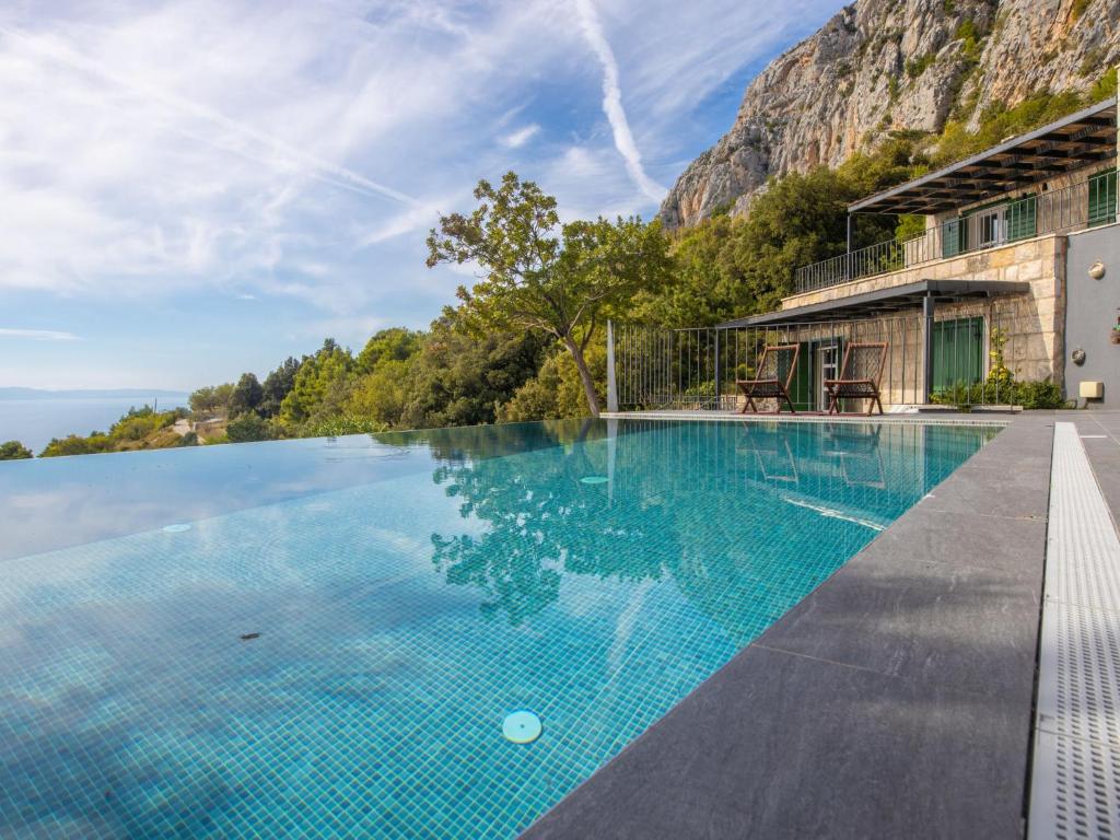 uma piscina de beiral infinito num resort com uma montanha ao fundo em Villa 2M by Interhome em Kotišina