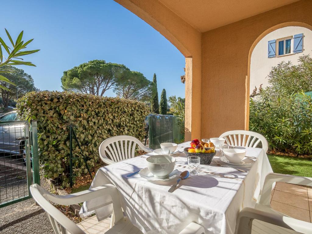 - une table blanche avec des chaises blanches et une table avec de la nourriture dans l'établissement Apartment Le Lagon Bleu-5 by Interhome, à Fréjus