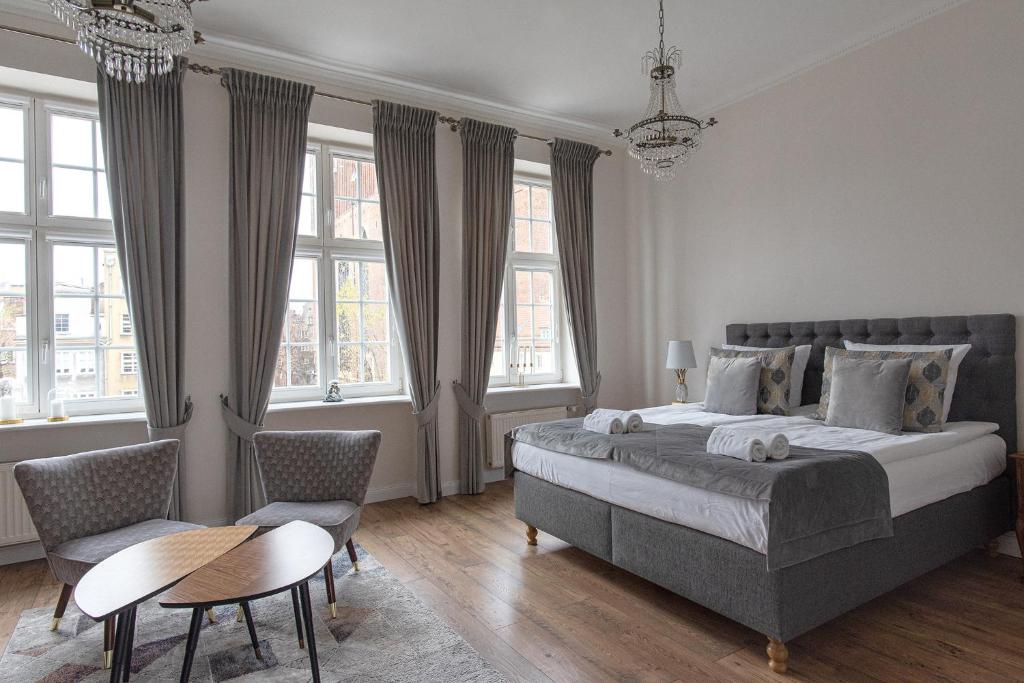 um quarto com uma cama grande, uma mesa e cadeiras em Olives Marina Apartment Gdańsk em Gdansk
