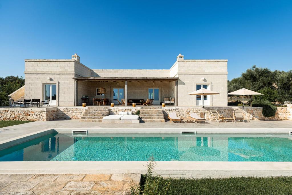 a house with a swimming pool in front of a house at Villa Margareta in Ostuni