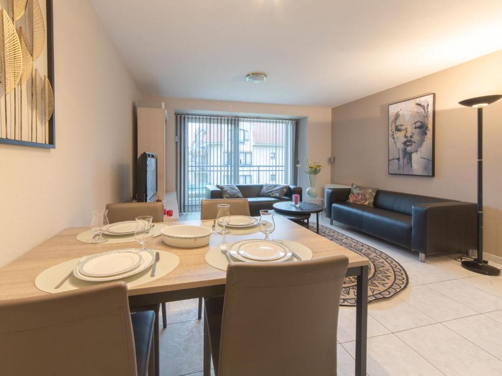 ein Esszimmer und ein Wohnzimmer mit Tisch und Stühlen in der Unterkunft Apartment De vakantieduinen aan zee by Interhome in Mispelburg