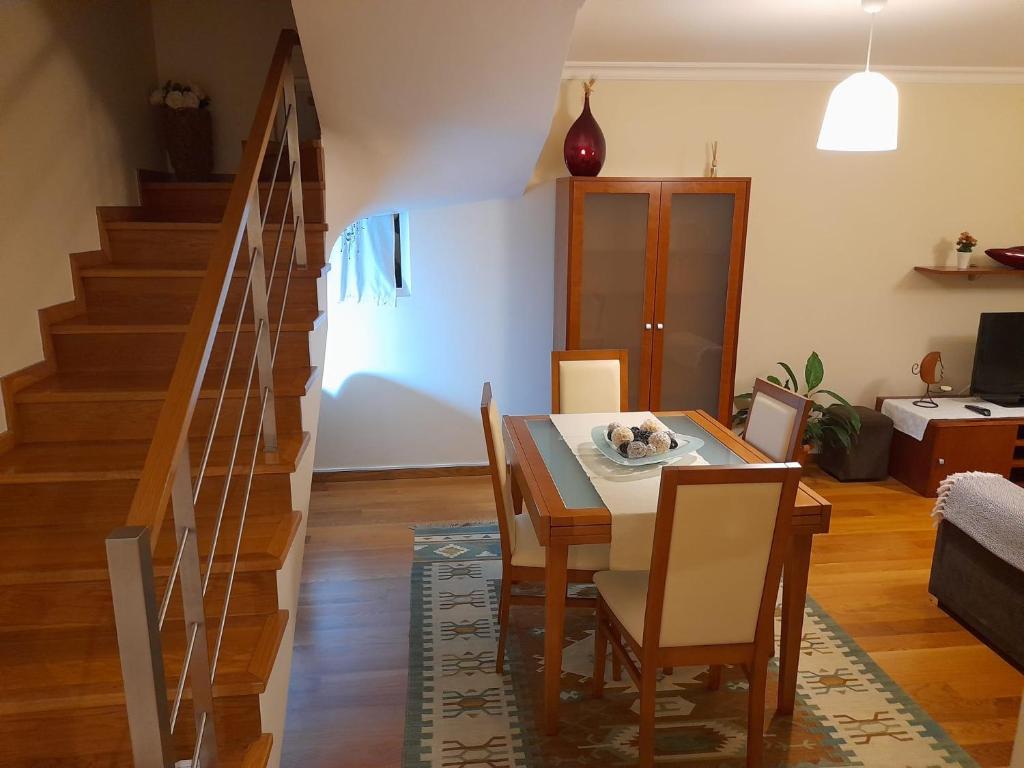 une salle à manger avec une table, des chaises et un escalier dans l'établissement Duplex da Fontinha, à Santa Cruz