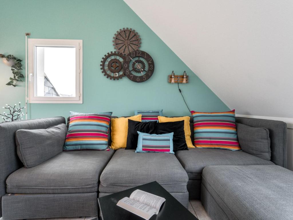 a living room with a gray couch with colorful pillows at Apartment Le Hoche-1 by Interhome in Quiberon