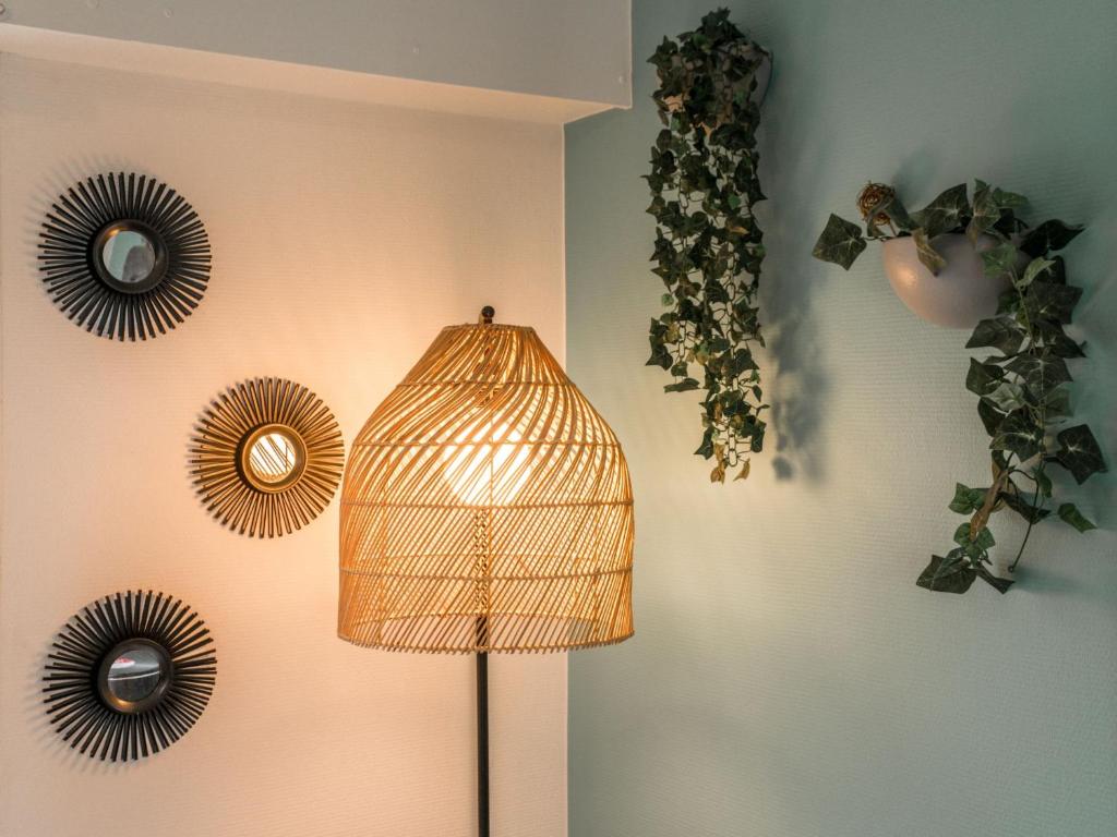 a lamp with a bird cage on a wall at Apartment Le Hoche-1 by Interhome in Quiberon