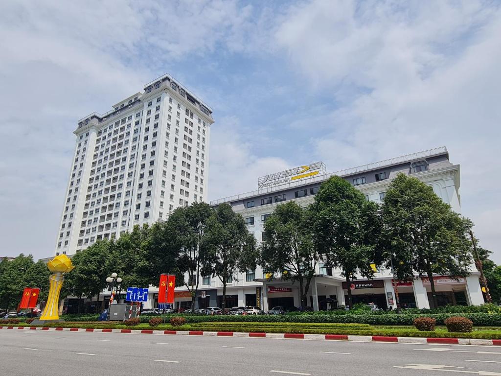 un grand bâtiment blanc en face d'une rue dans l'établissement Viet Long Complex Residence, à Bắc Ninh